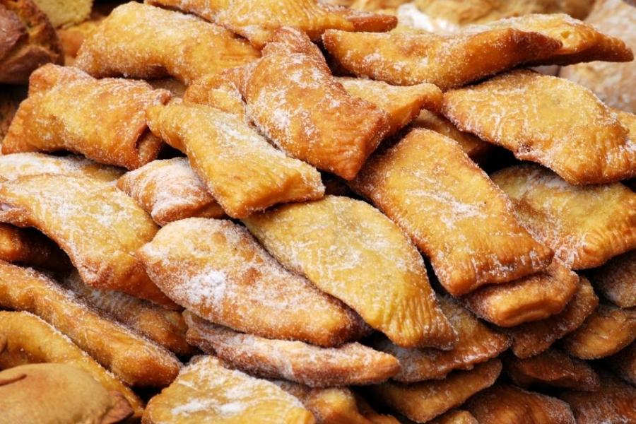 Una pila de casadielles asturianos espolvoreados con azúcar.