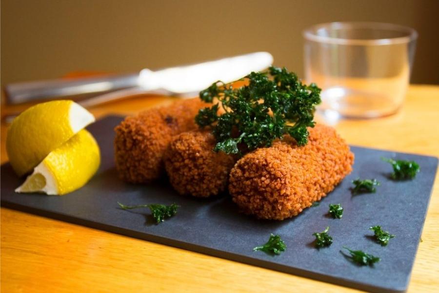 Croquetas de pescado decoradas con perejil y limón.