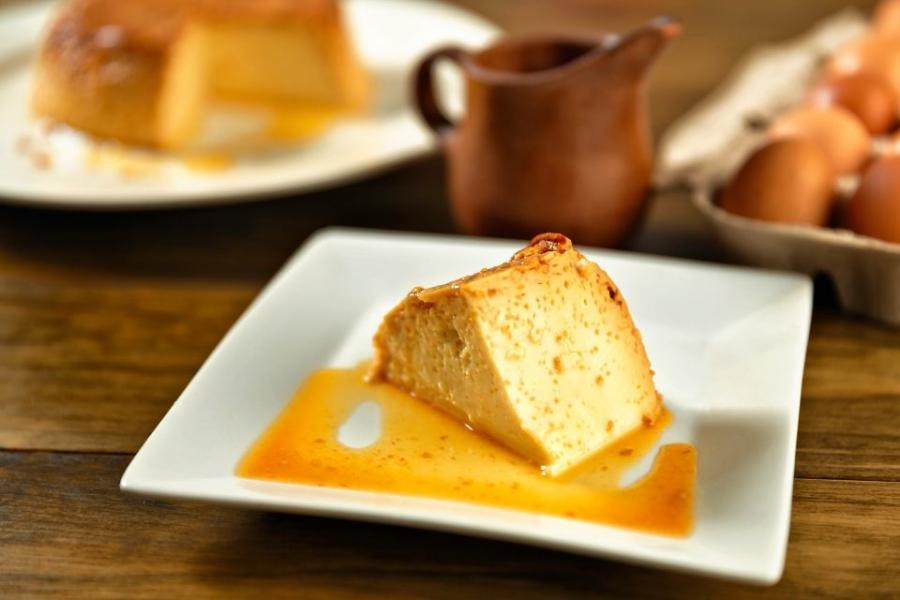 Un plato cuadrado con un trozo de quesillo venezolano.