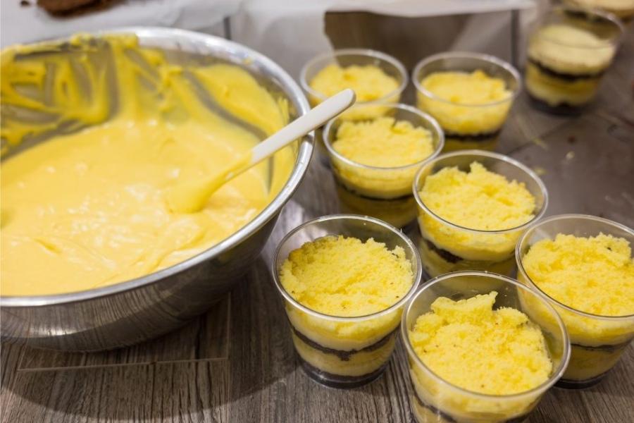 Repartiendo crema helada de coco y mango entre recipientes individuales.