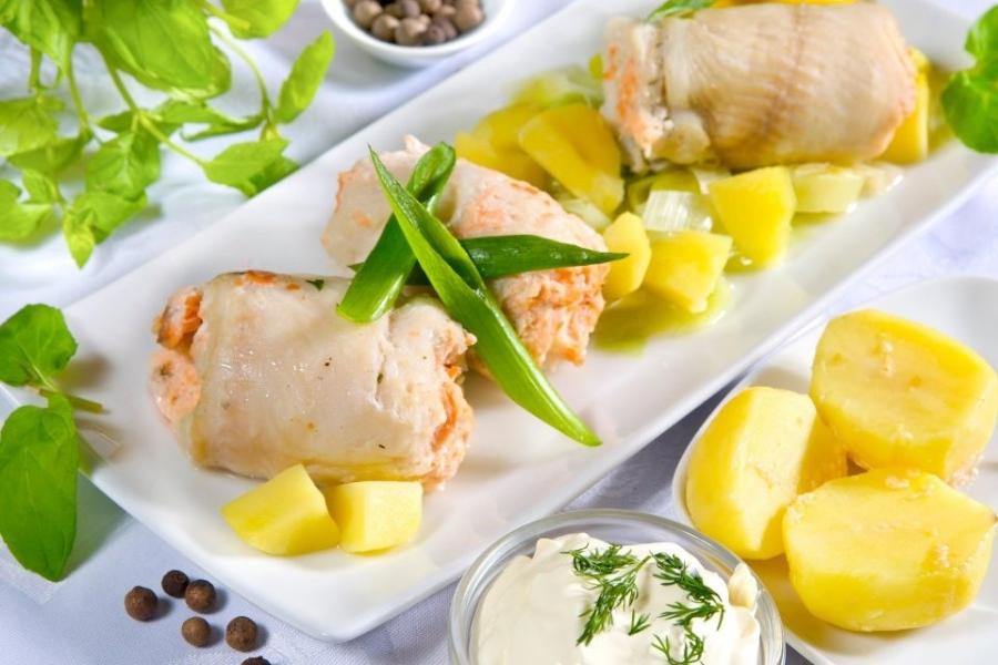 Filetes de pescado rellenos enrollados, acompañados con patata codida y aliñada.