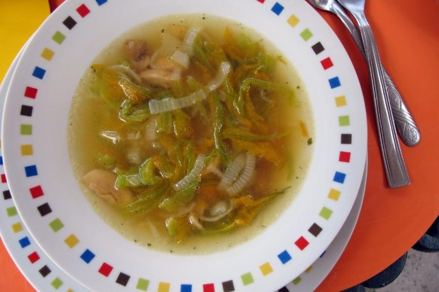Sopa de flor de calabaza con cebolla y champiñon en un plato.