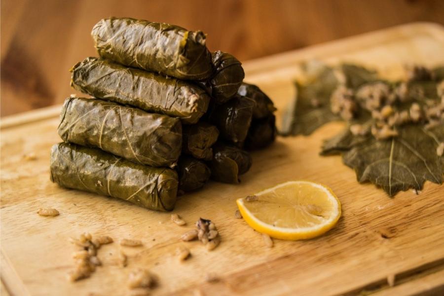 Hojas de parra rellenas dea arroz sobre una tabla de cortar.