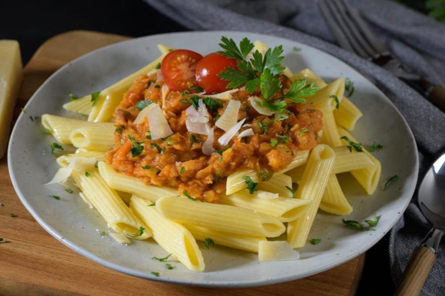 Un plato de pasta con salsa de lentejas.