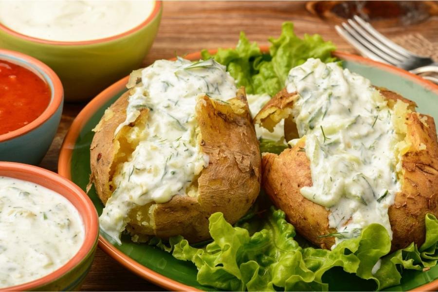 Una patata asada cubierta con tzatziki.