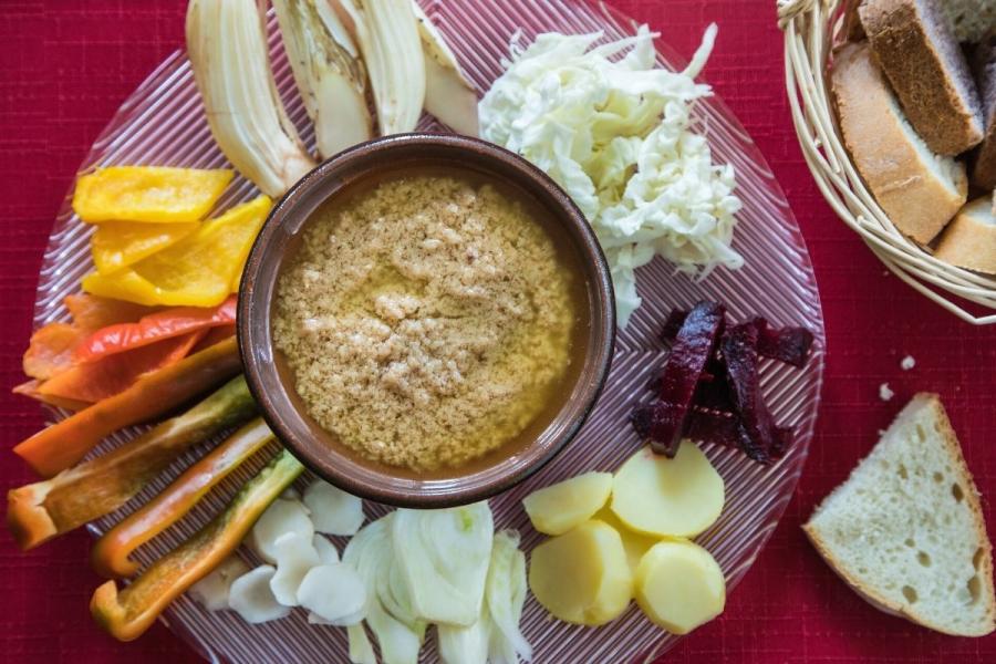 Un cuenco con bagna càuda rodeado de hortalizas troceadas.