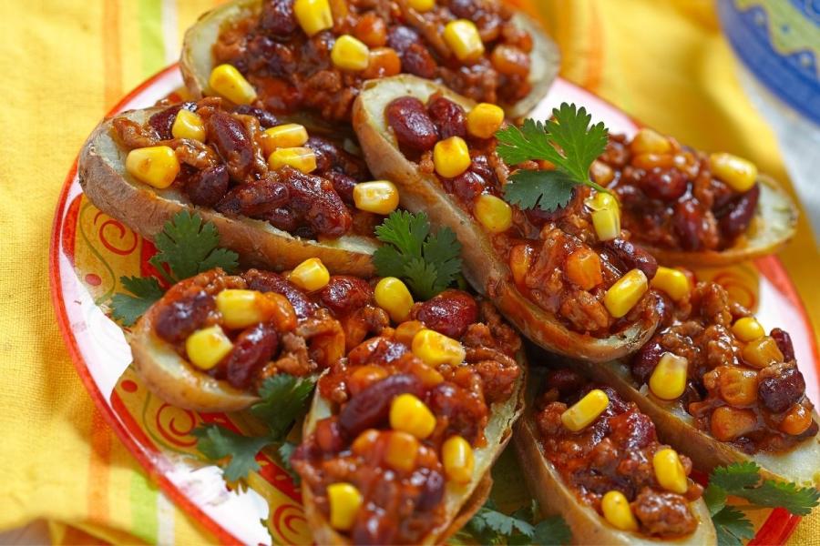 Cáscaras de patata rellenas de carne, maíz y alubias.