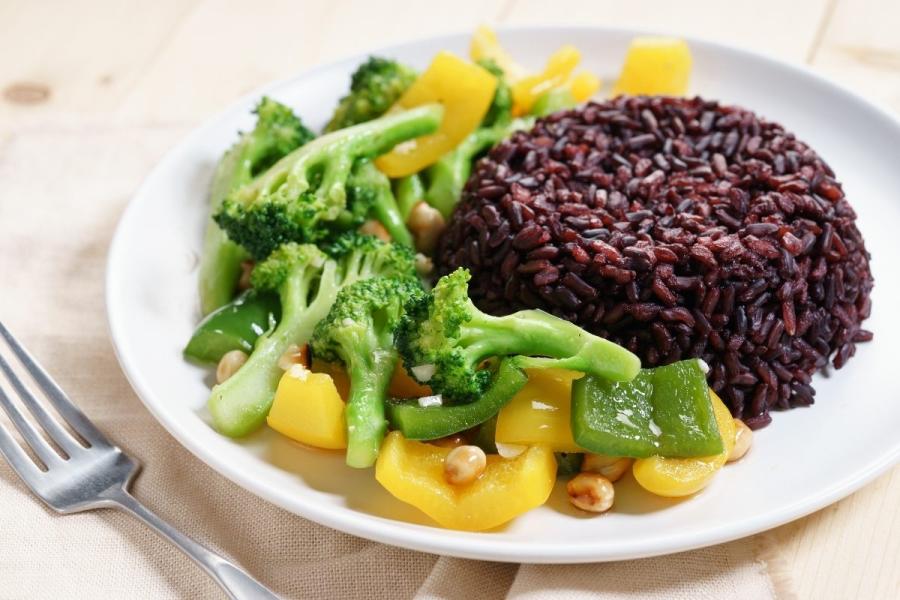 Arroz negro variedad Venus moldeado acompañado de verduras salteadas.