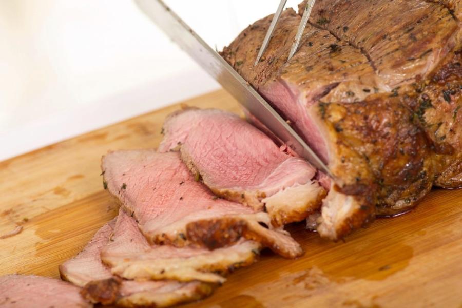 Cortando lonchas de un trozo de carne asada.