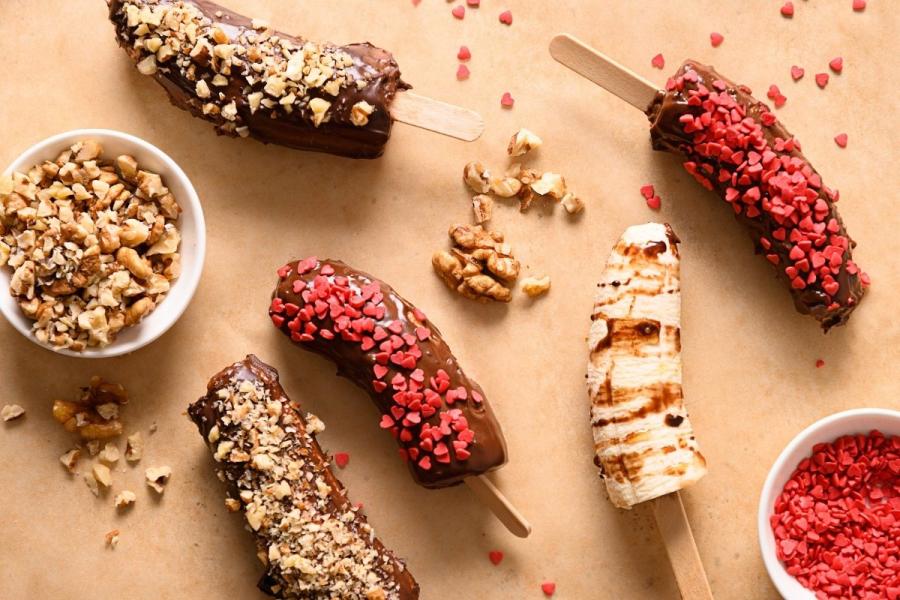 Paletas de plátano cubiertas con chocolate fundido y varios tropezones.