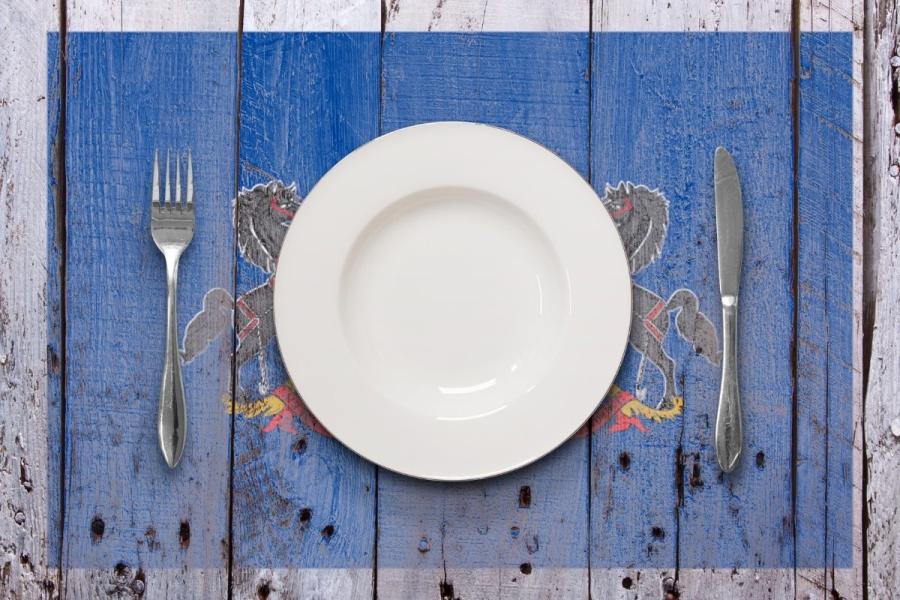 Concepto la cocina de Pensilvania con un plato blanco y cubiertos sobre una mesa rústica.