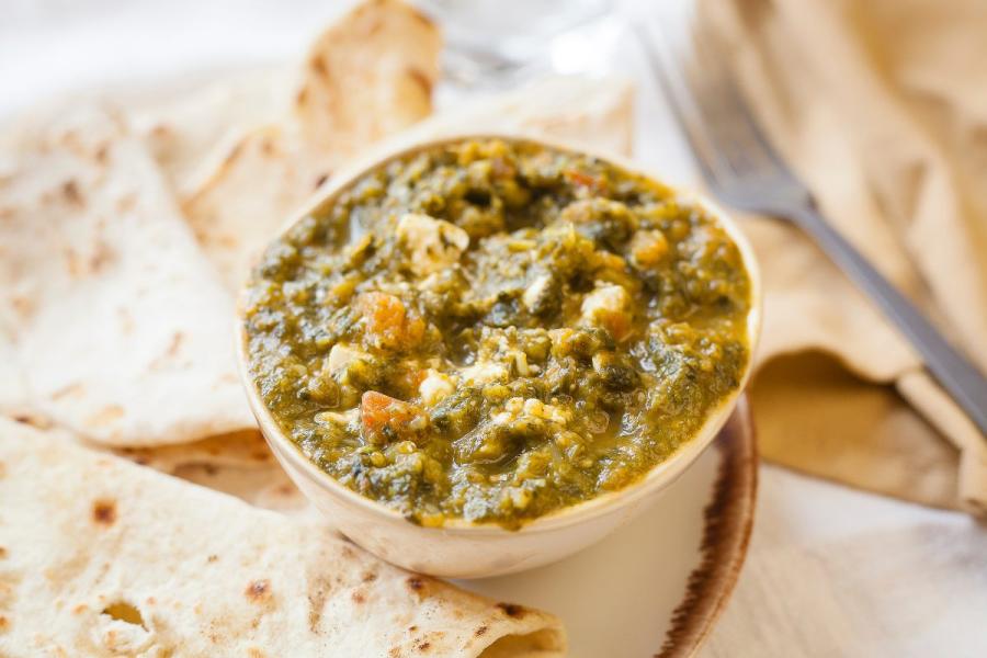 Queso panir guisado con espinacas sobre pan naan.