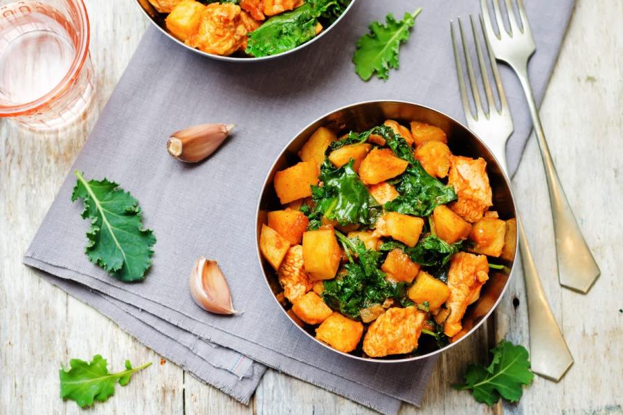 Cazuelita de pollo guisado con batata y hojas verdes.