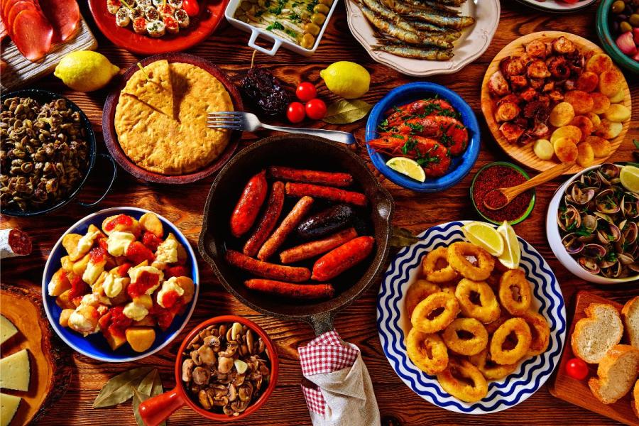 Tapas variadas, incluyendo tortilla de patata, almejas a la marinera y otras.