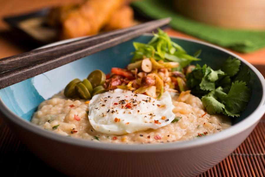 Un plato de congee con varios ingredientes como complemento.