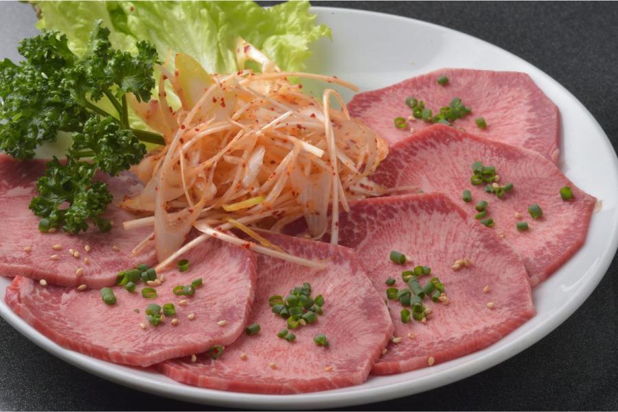 Lonchas de lengua de vaca fiambre servidas con ensalada.