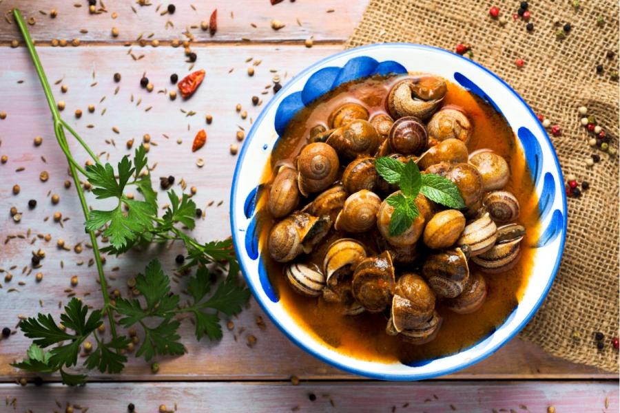 Una cazuela con caaracoles en salsa picante.