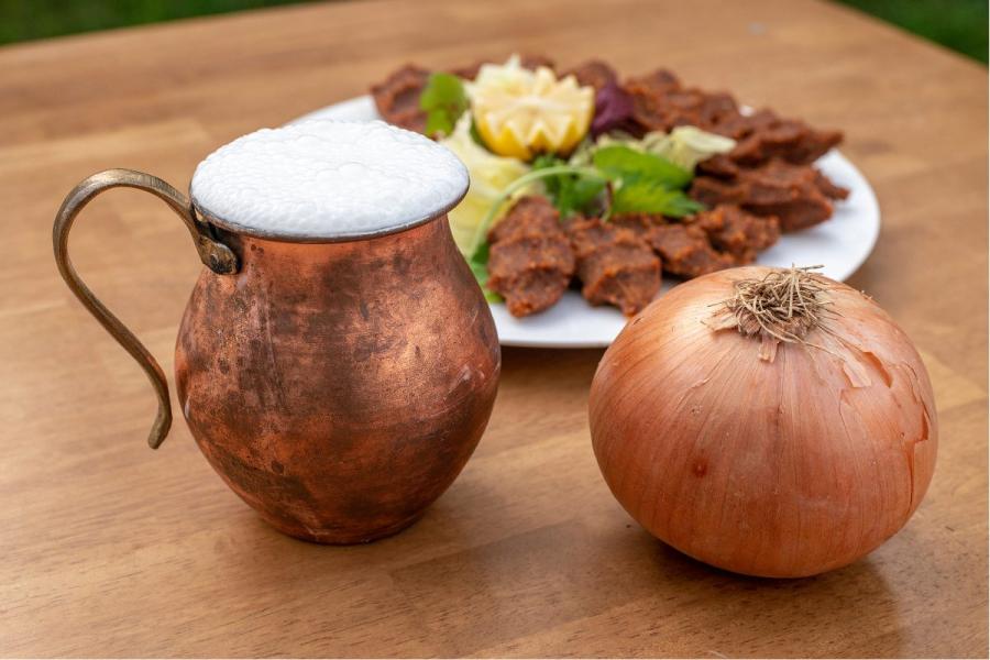 Ayran en una jarrita de cobre acompañado por un aperitivo turco.
