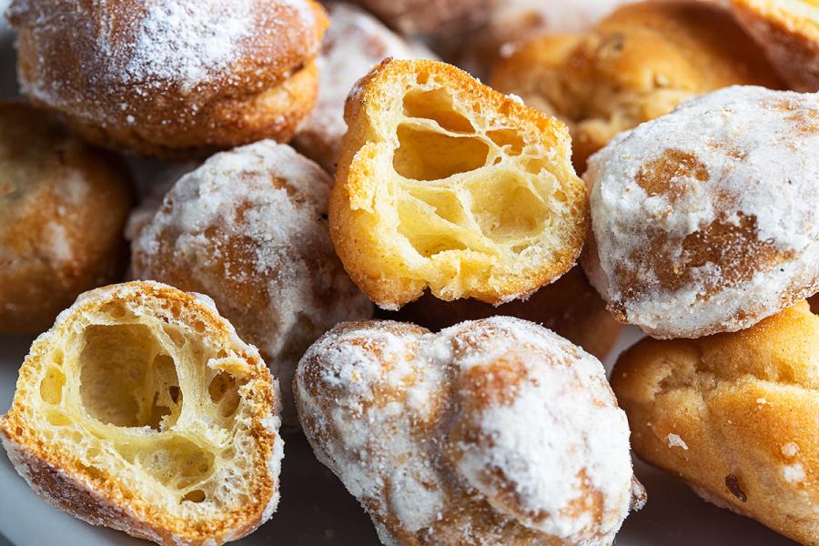 Buñuelos de viento recién hechos, uno abierto mostrando el interior esponjoso.