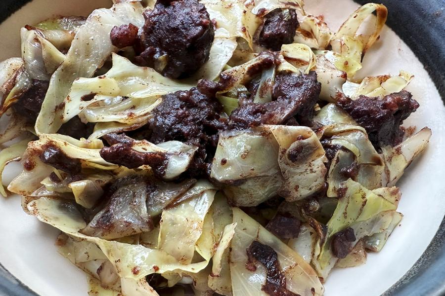Un plato de repollo con morcilla.