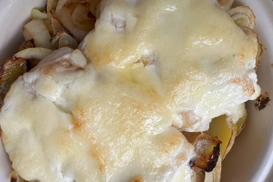 Detalle de bacalao al horno con mayonesa en una cazuela de barro.