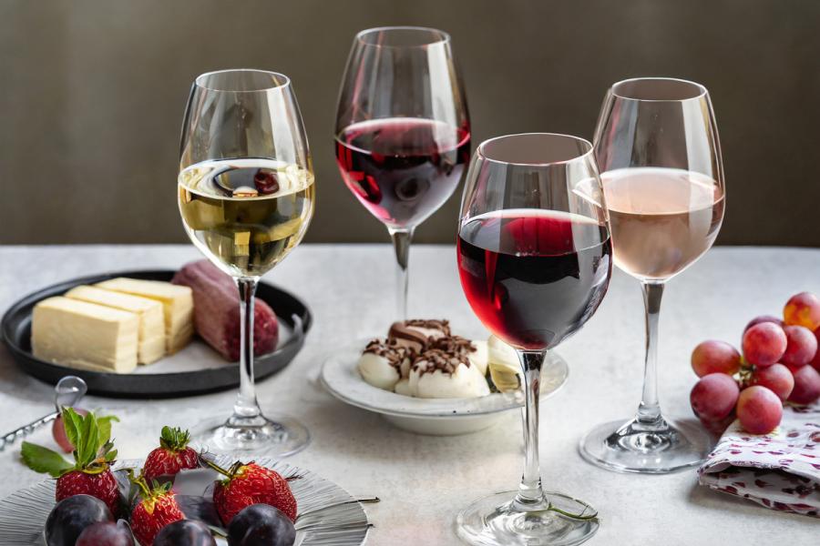 Copas con distintos tipos de vino y varios postres sobre una mesa.