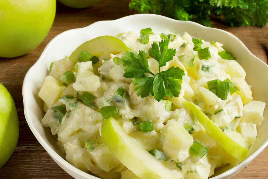 Una ensaladera con ensalada irlandesa de patata y manzana.