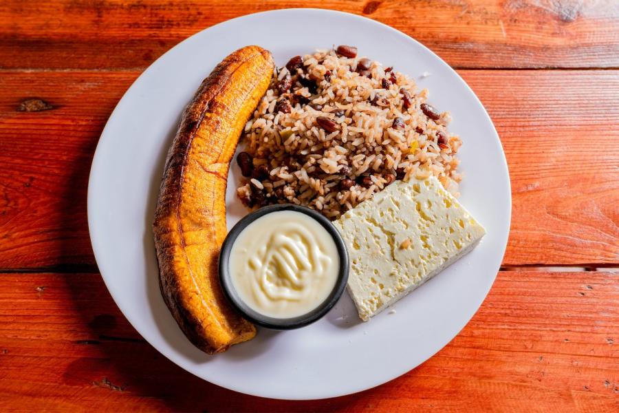 Gallo pinto, arroz con alubias negras, con queso y plátano frito.