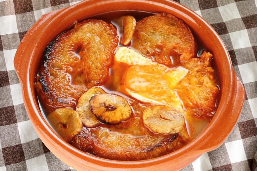 Una cazuela de barro con sopa de ajo castellana.