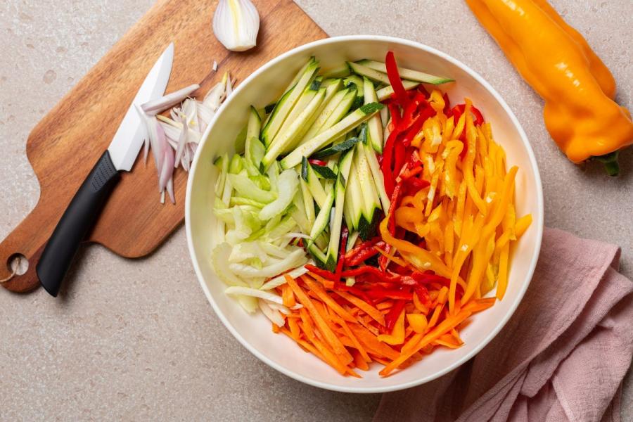 Un cuenco con verduras cortadas en juliana.