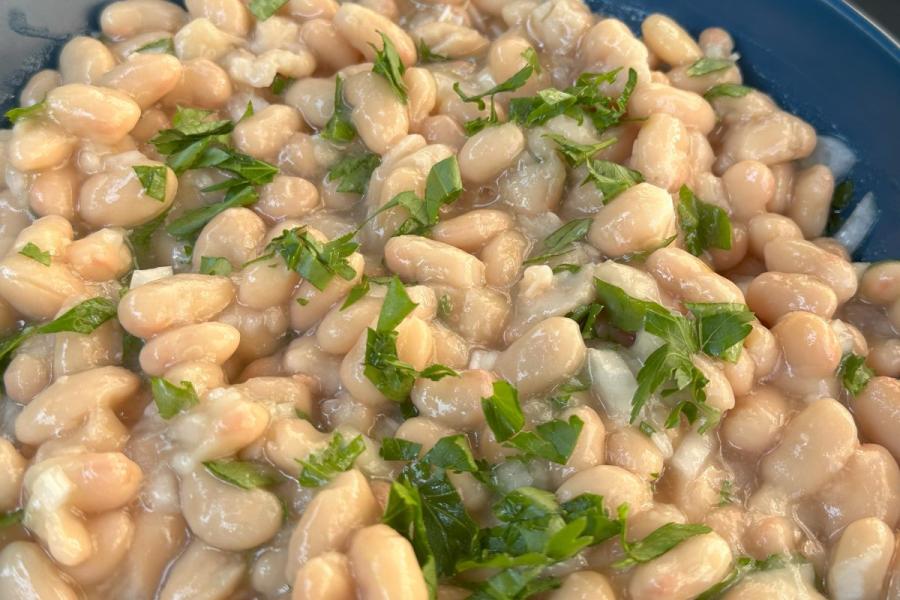 Alubias blancas en ensalada en un plato hondo.