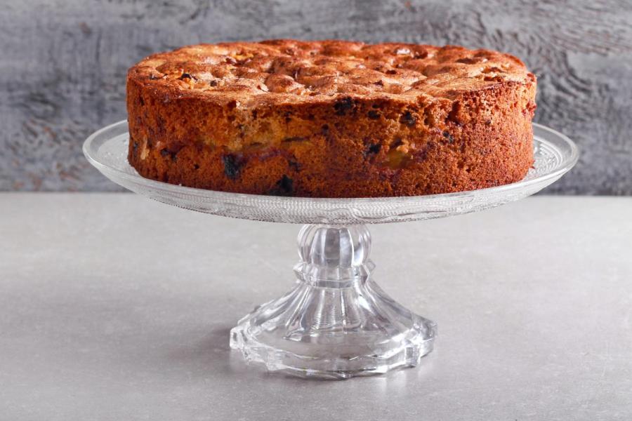 Torta de nueces y pasas en una fuente de pasteleria con pie alto.