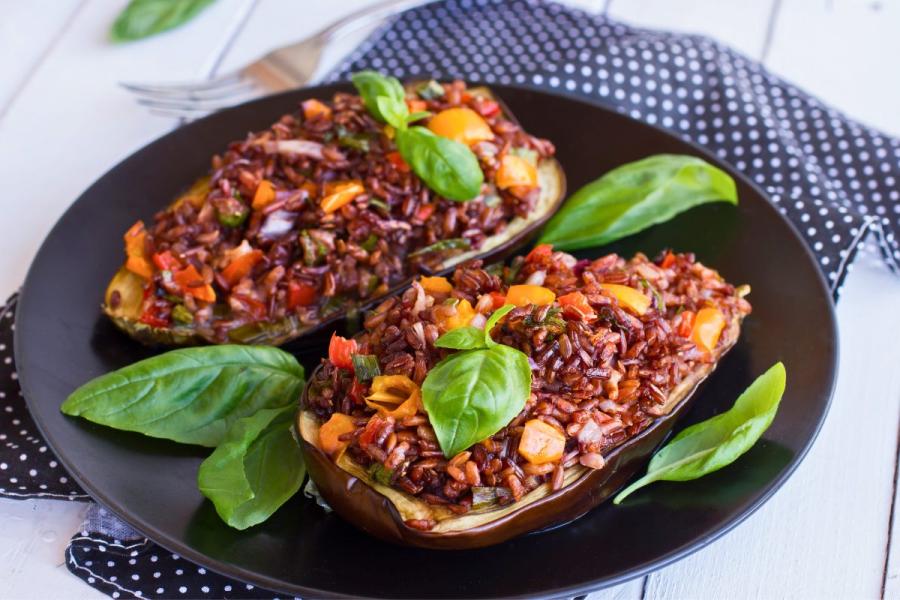 Berenjenas rellenas de arroz rojo y verduras, sin queso rallado.