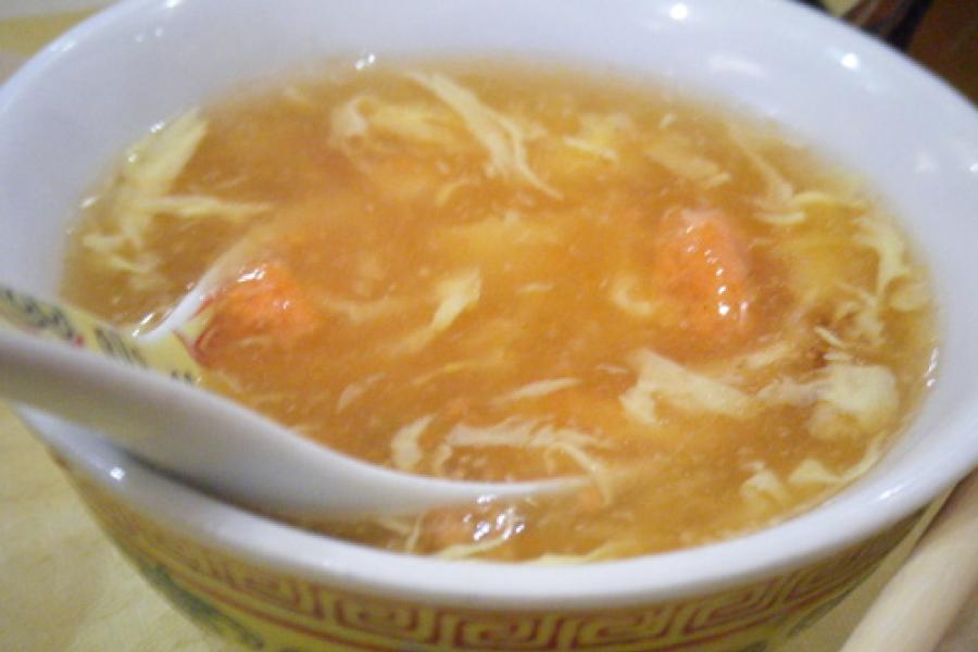 Bol con sopa y cuchara de cerámica.