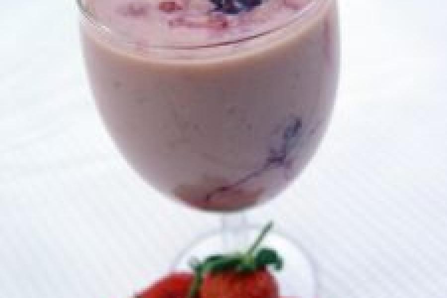Batido de fresa servido en copa y decorado con fruta fresca.