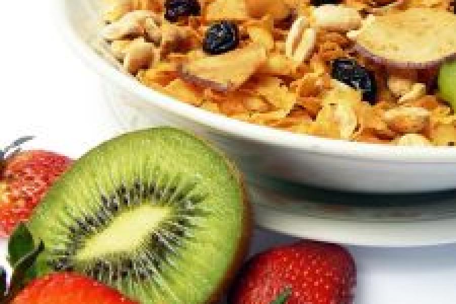 Fruta fresca cortada y un cuenco con granola.