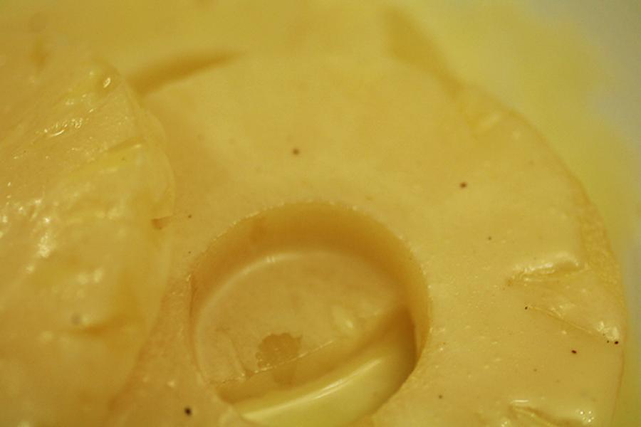 Rodajas de piña con salsa de chocolate blanco.