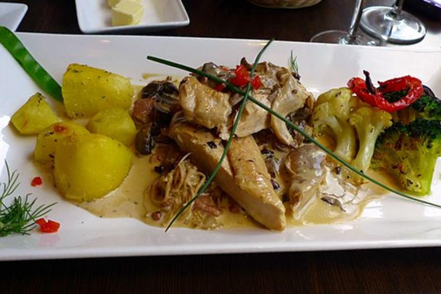Suprema de pollo con salsa y acompañamiento.