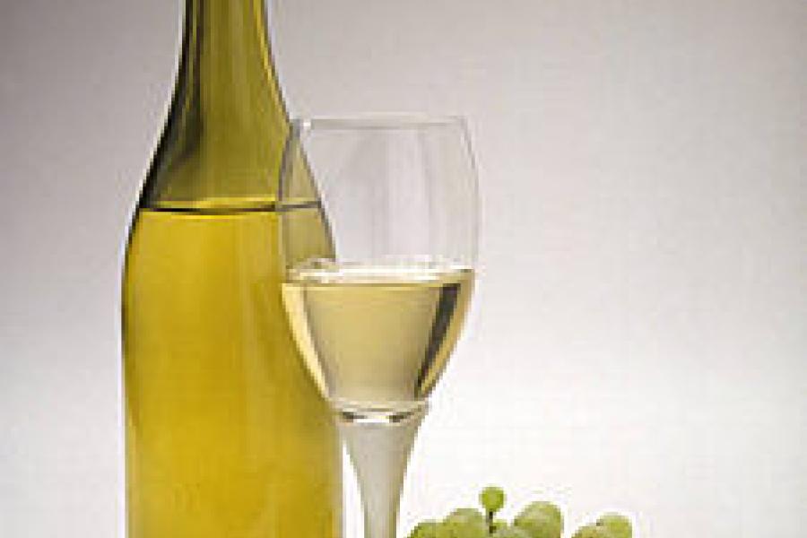 Uvas blancas, botella y copa de vino blanco.