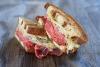 Bocadillo Reuben con corned beef ahumado, queso y sauerkraut.