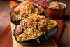 Dos mitades de calabaza rellena con salchicha y arroz.