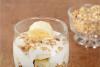 Copa de plátano, yogur y granola en vaso de globo.