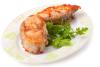 Un plado de rodajas de pescado con tomate decoradas con ramitas d eperejil.
