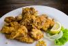 Sesos de cordero rebozados y fritos, acompañados de limón, cebolla y lechuga.