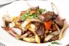 Un plato con lomo saltado, carne y verduras salteadas con paatas fritas y una salsa sabrosa.
