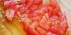 Tomate picado sobre una tabla de cortar de madera.